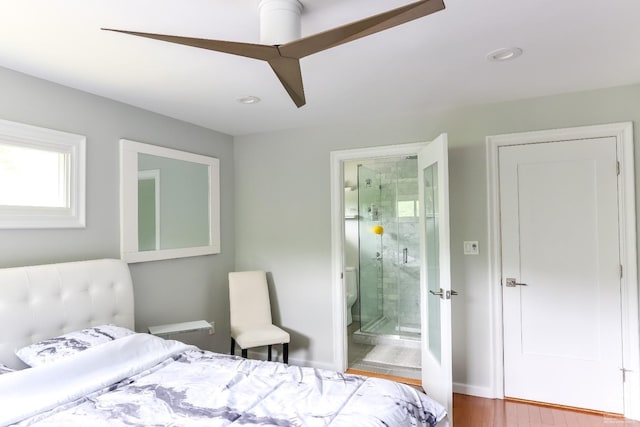 bedroom with hardwood / wood-style floors, ensuite bathroom, and ceiling fan