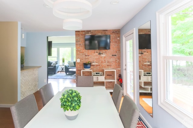 dining area with wood-type flooring and a healthy amount of sunlight