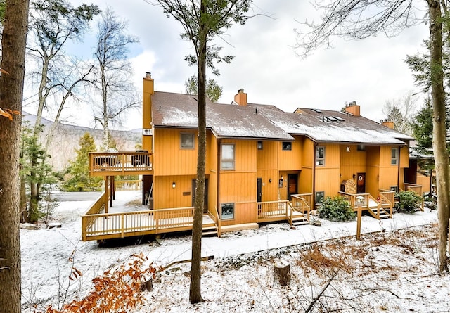 snow covered property featuring a deck with mountain view