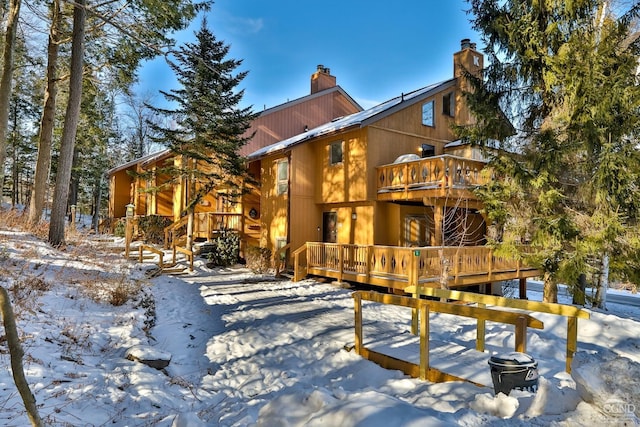 snow covered house with a deck