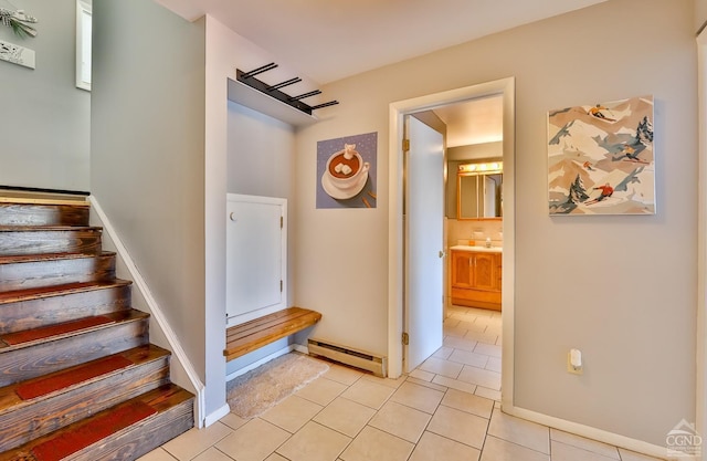 stairs featuring tile patterned floors and baseboard heating