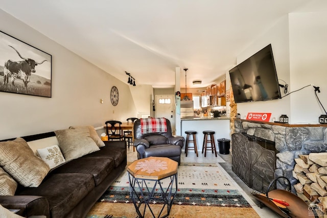 living room featuring a stone fireplace