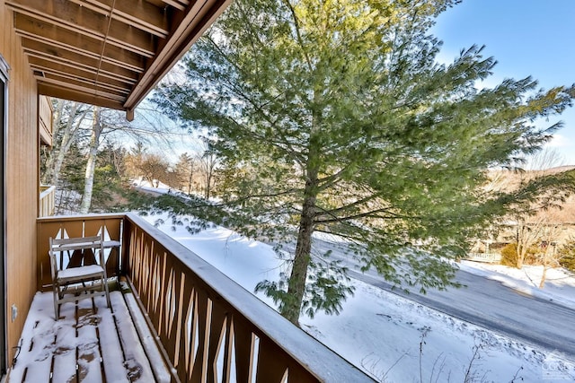 view of snow covered back of property