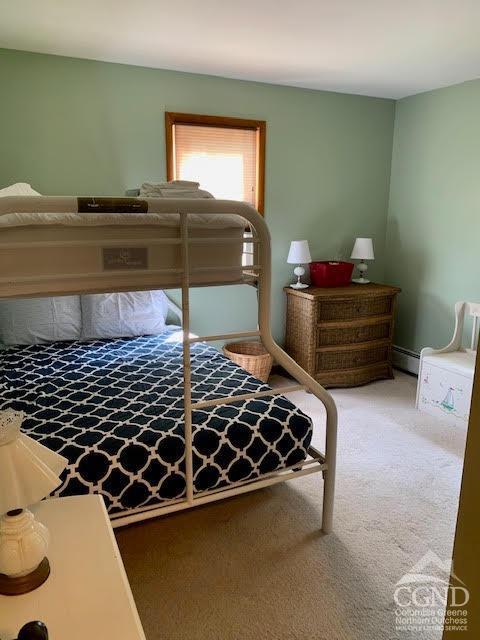 bedroom featuring carpet floors and a baseboard heating unit