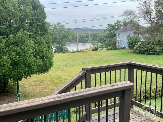 deck featuring a lawn and a water view