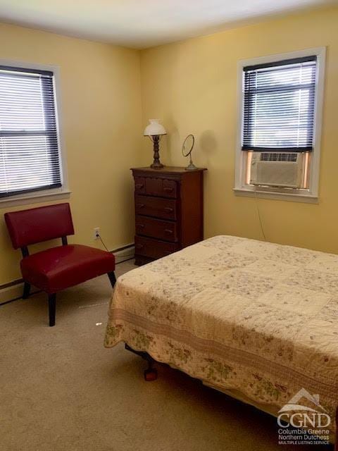 carpeted bedroom with cooling unit and baseboard heating