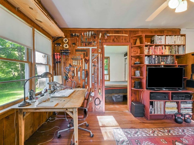 office space with a workshop area, wooden walls, and wood-type flooring