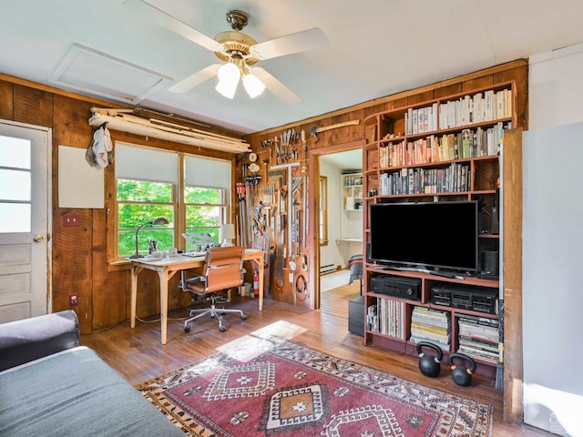 office area featuring hardwood / wood-style flooring, ceiling fan, and wooden walls