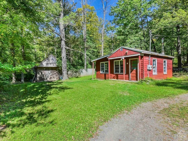 view of front of property with a porch, a garage, an outbuilding, and a front lawn