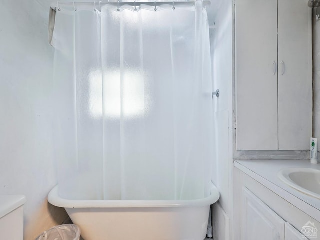 bathroom with a bathing tub, vanity, and toilet