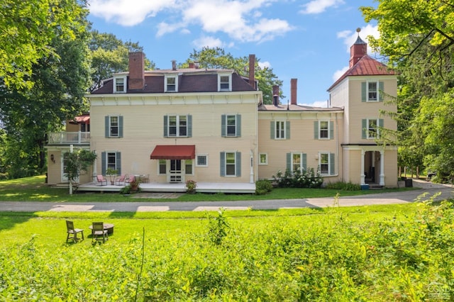 back of house with a lawn and a deck