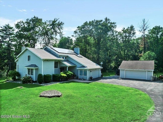 view of front facade featuring a front yard, a garage, and an outdoor structure