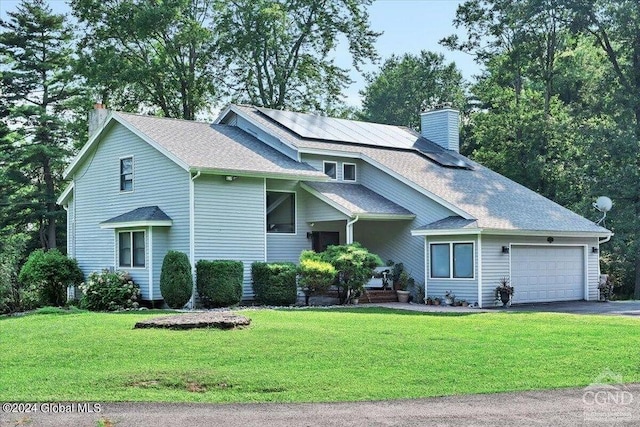 view of front of home featuring solar panels, a garage, and a front yard