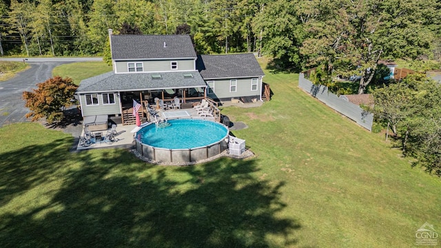 back of property with a lawn and a swimming pool side deck