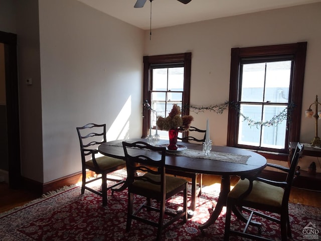 dining area featuring baseboards, wood finished floors, and a ceiling fan