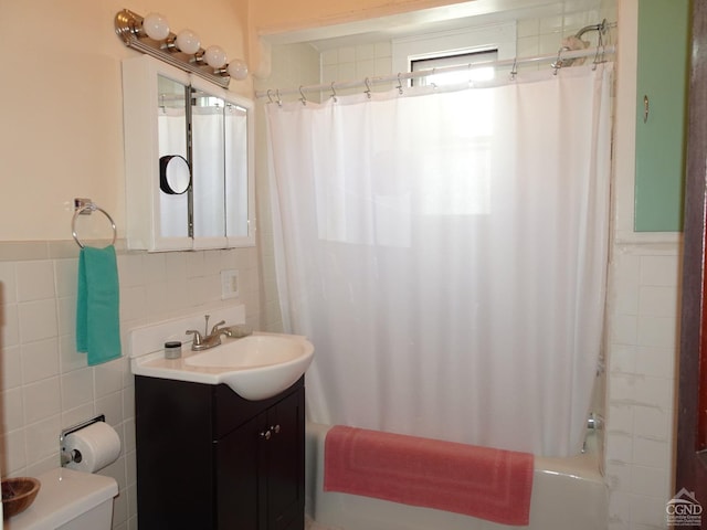bathroom with toilet, tile walls, shower / bath combo, and vanity