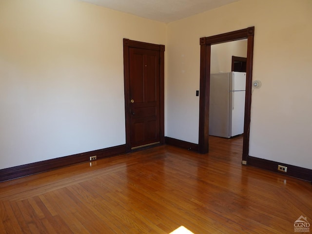 unfurnished room featuring wood finished floors and baseboards