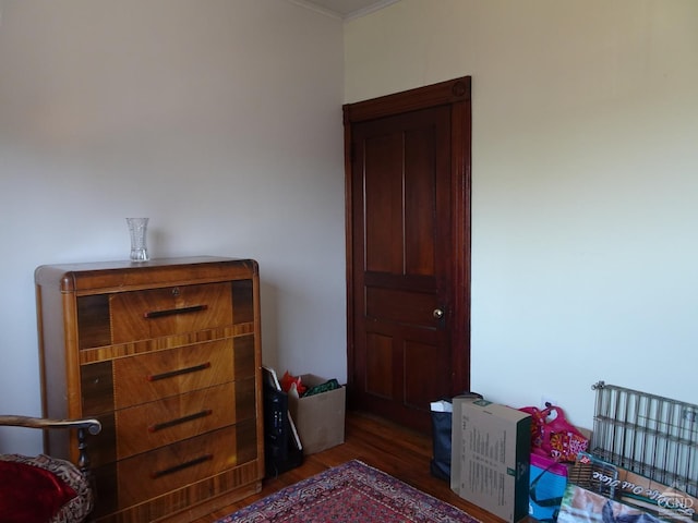 bedroom featuring wood finished floors and ornamental molding
