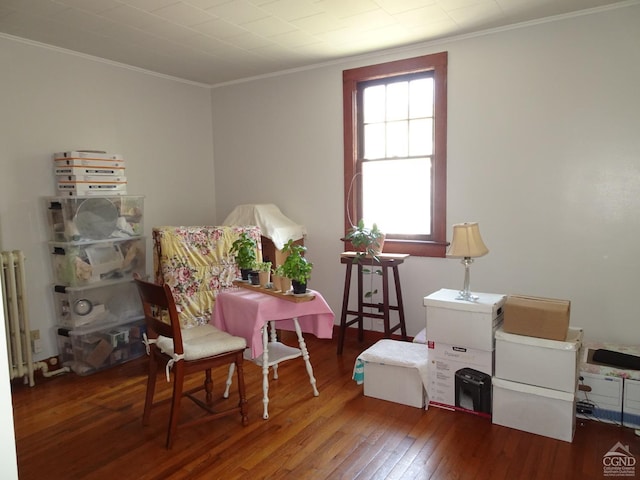 sitting room with hardwood / wood-style flooring and ornamental molding