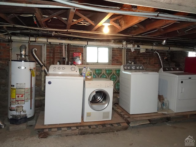 laundry room featuring gas water heater, brick wall, separate washer and dryer, and laundry area