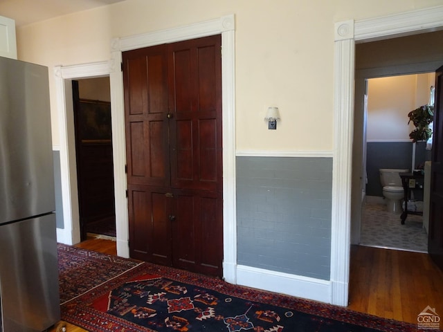 interior space featuring wood finished floors and a wainscoted wall