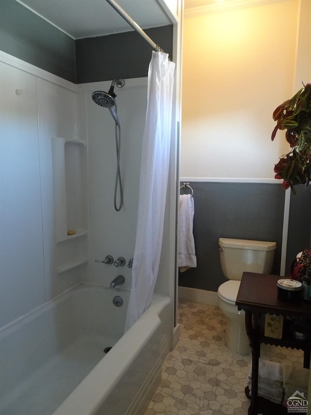full bath with shower / bath combo, toilet, a wainscoted wall, and tile patterned flooring