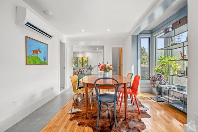 dining area featuring hardwood / wood-style floors and a wall mounted AC