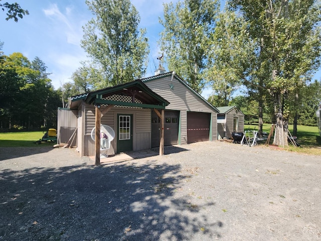 view of front of property featuring a storage unit and a garage