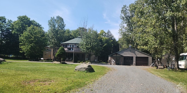 view of front of property with a front yard, a deck, a garage, and an outdoor structure