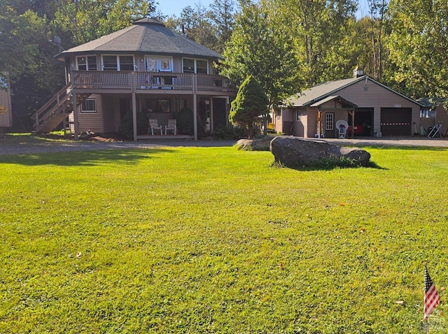 rear view of property with a lawn, a garage, and a deck