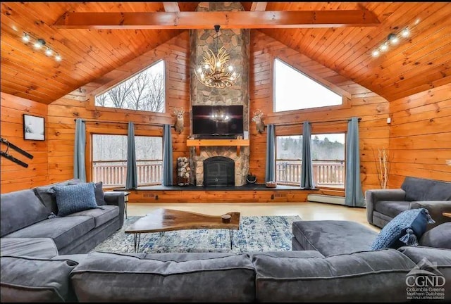 living room featuring wood walls, a fireplace, high vaulted ceiling, and track lighting