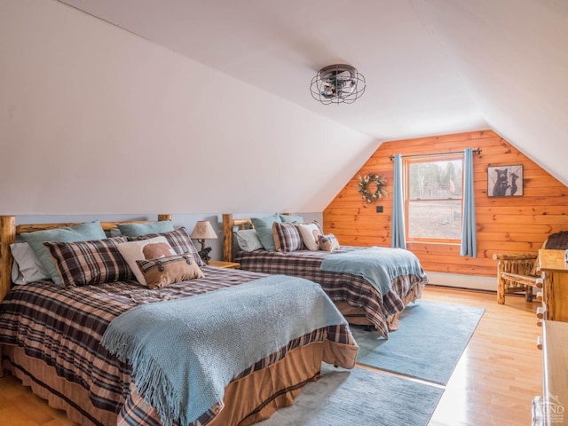 bedroom with wooden walls, vaulted ceiling, and light wood-type flooring