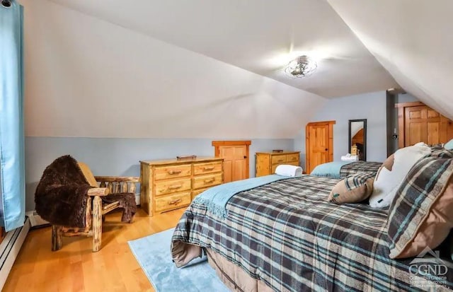 bedroom with a baseboard radiator, vaulted ceiling, and light wood-type flooring