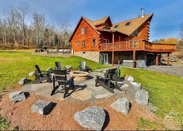 back of property with a yard, a patio, a fire pit, and a deck