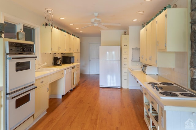 kitchen featuring decorative backsplash, ceiling fan, white appliances, and light wood-type flooring