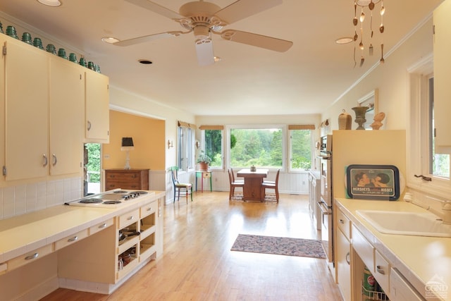 kitchen featuring ceiling fan, sink, white gas cooktop, backsplash, and light hardwood / wood-style floors