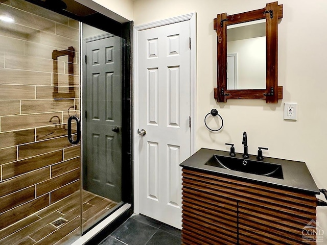 bathroom with tile patterned floors, a shower with door, and vanity