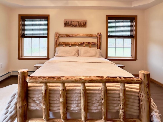 bedroom with a baseboard radiator and multiple windows