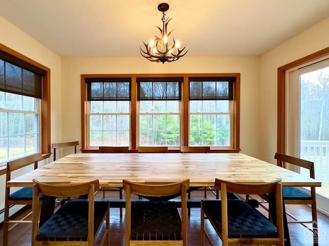 dining area with dark hardwood / wood-style flooring, plenty of natural light, and a chandelier