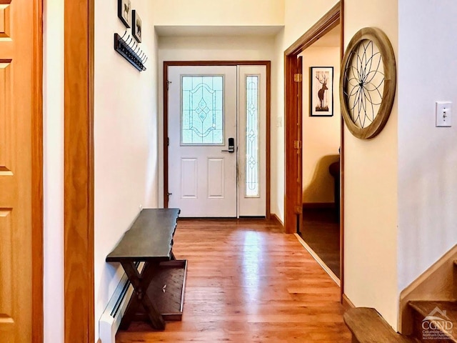 foyer entrance featuring wood-type flooring and a baseboard radiator