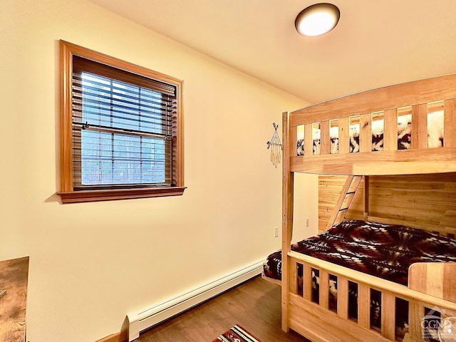 bedroom with hardwood / wood-style floors and a baseboard radiator