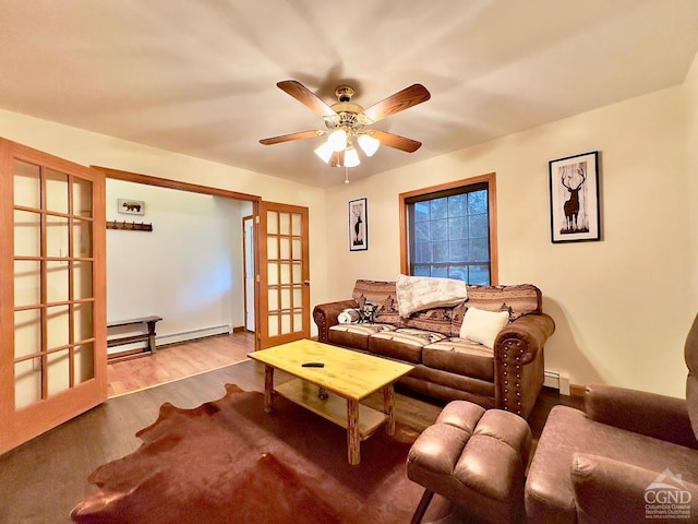 living room featuring ceiling fan, a baseboard heating unit, light wood-type flooring, and french doors