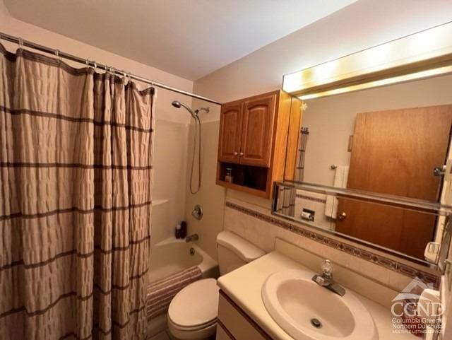 full bathroom featuring decorative backsplash, shower / tub combo with curtain, vanity, and toilet