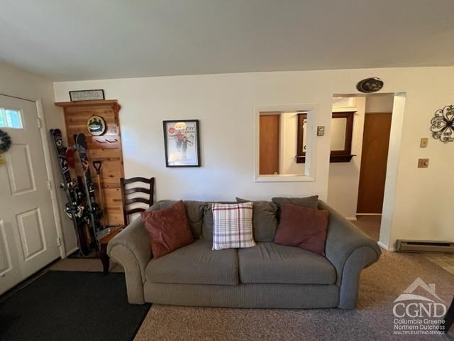 carpeted living room featuring baseboard heating