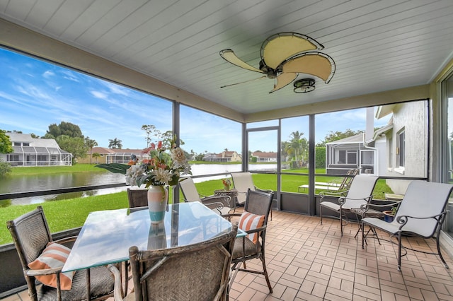 sunroom featuring a water view