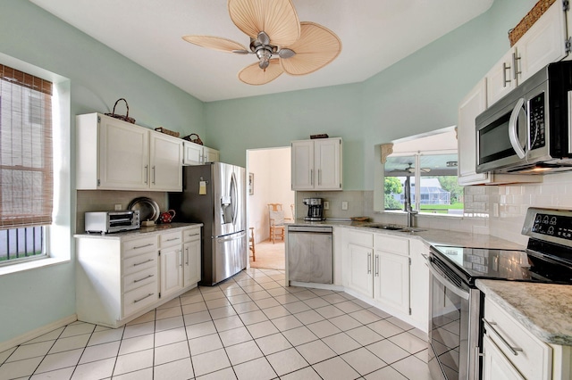 kitchen featuring white cabinets, stainless steel appliances, and decorative backsplash