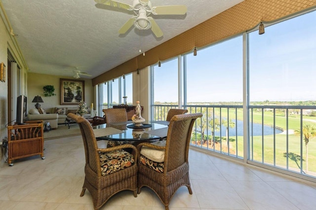 sunroom / solarium featuring ceiling fan