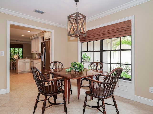 tiled dining room featuring a healthy amount of sunlight, ornamental molding, and a chandelier