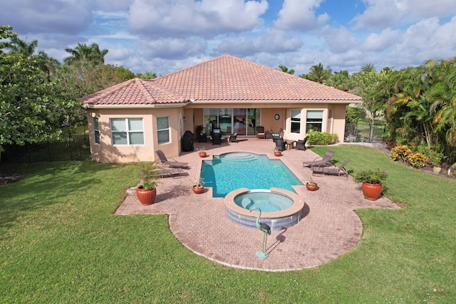 view of pool with an in ground hot tub, a yard, and a patio area