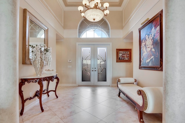 foyer with crown molding, french doors, a chandelier, and a high ceiling